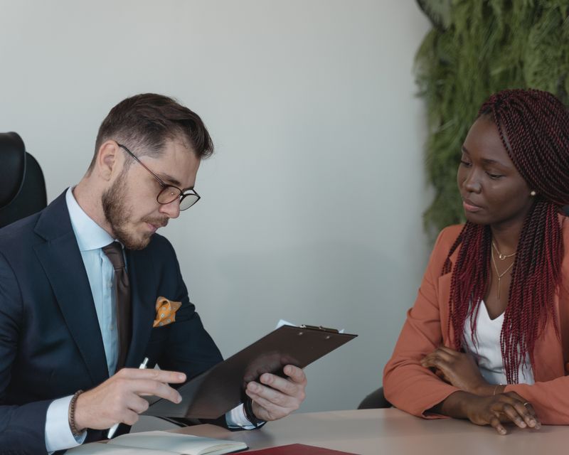 A recruiter and a candidate talking across a table in a bright office