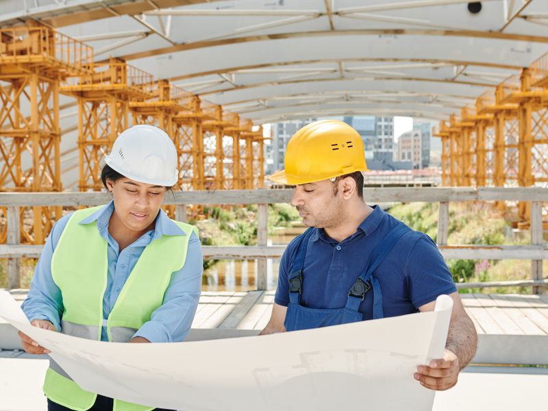 An engineering team reviewing blueprints on a construction site